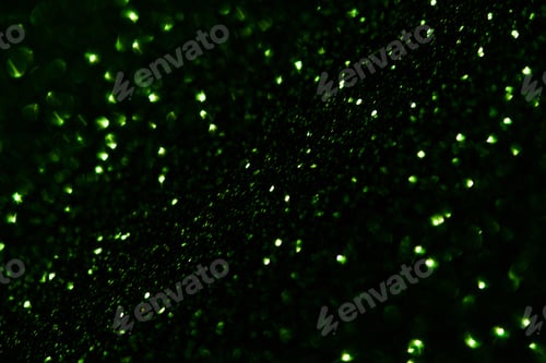 Preview: Green Glitter Particles Scattered Across Dark Surface With Tiny Bright Highlights And Dense Shallow