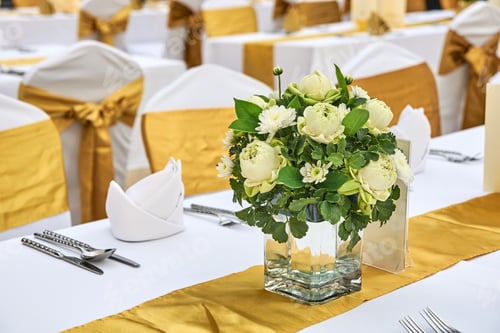 Preview: Elegant wedding reception table with floral centerpiece and gold decorations