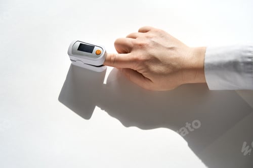 Preview: Person Monitoring Oxygen Saturation With Fingertip Pulse Oximeter Placed On Finger On Flat Surface