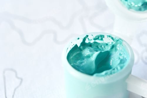 Preview: Close-up of turquoise paint texture in a container for artistic projects