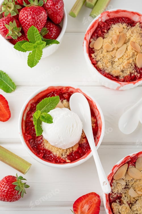 Preview: Rhubarb and strawberry crumble with a scoop of ice cream on top in a baking form