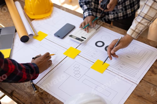 Preview: Architect discussing housing project with blueprints and miniature house. Architects gather in offic