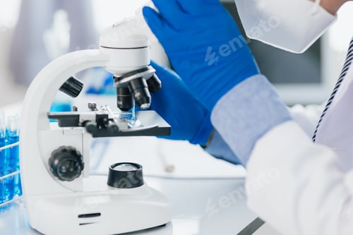Preview: Scientist working microscope doing research in laboratory. Scientist in a lab, adjusting a microscop