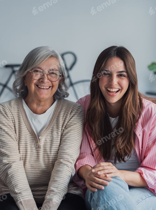Preview: Smiling grandmother and granddaughter enjoying family happiness at home