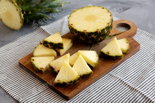 Preview: Organic Pineapple Wedges Freshly Sliced on a Cutting Board, side view.