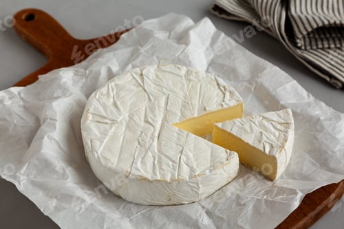 Preview: Organic White Brie Cheese on a Wooden Board, side view.
