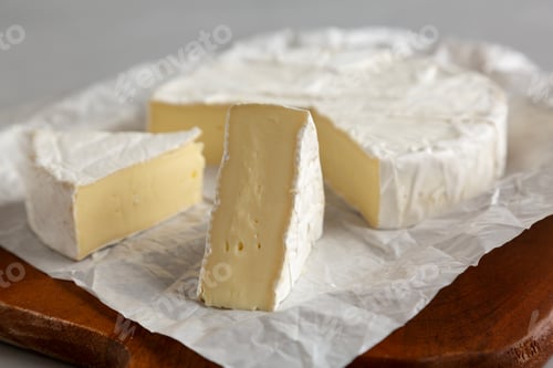 Preview: Organic White Brie Cheese on a Wooden Board, side view.
