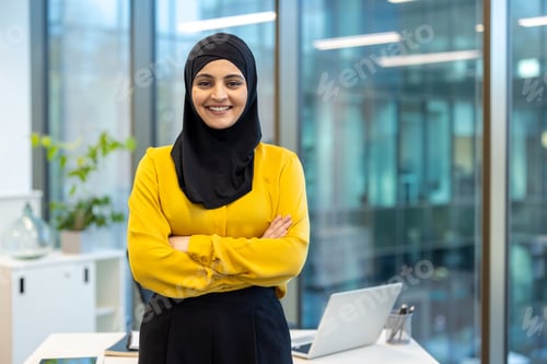 Preview: Portrait of young successful Muslim woman in hijab at workplace inside office, office worker smiling