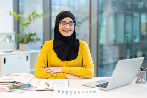 Preview: Muslim businesswoman working in modern office environment with laptop