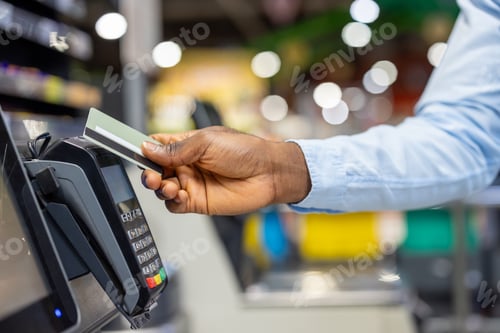 Preview: Hand swiping credit card at payment terminal in store