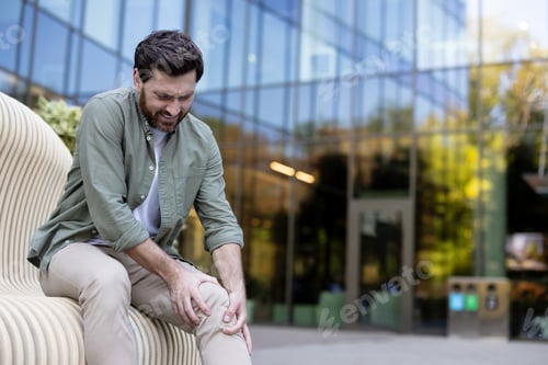 Preview: Man suffering from severe knee joint pain outdoors