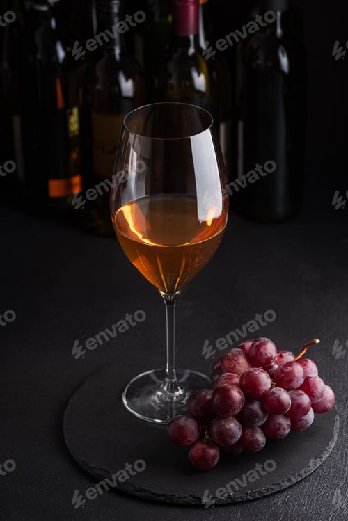 Preview: Rose wine glass and red grapes on slate