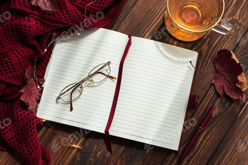 Preview: Autumn flat lay with warm tea, open notebook, and fall decorations