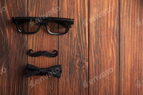 Preview: Father's Day concept with glasses mustache and bow tie on brown wooden background