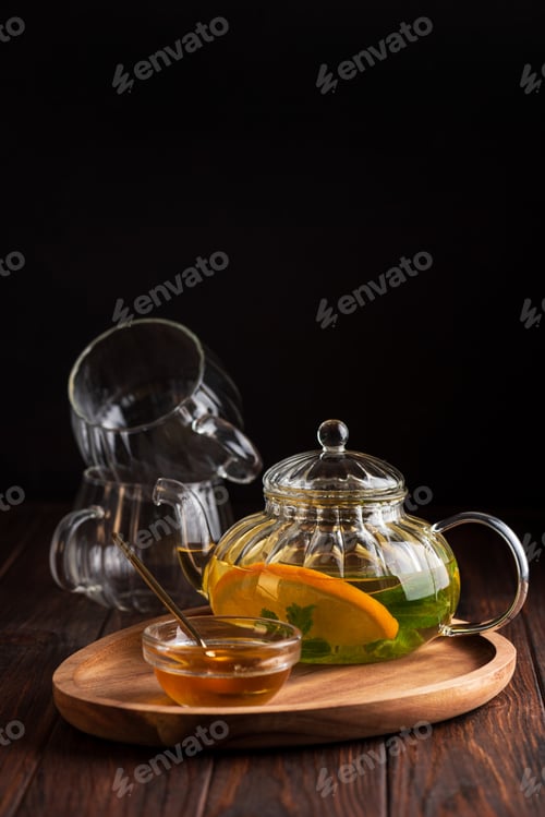 Preview: Glass teapot brewing herbal tea with orange and mint