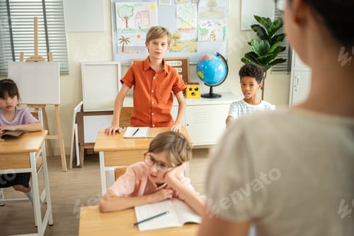 Preview: Schoolboy standing and answering in front of class