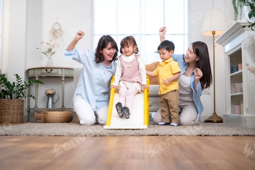 Preview: Mother and children enjoying a playful moment on a slide at home