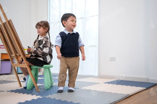 Preview: Little girl drawing while a boy walks around, reflecting independent activities