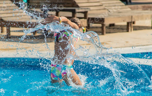 Preview: A child in the pool splashes water. Selective focus.