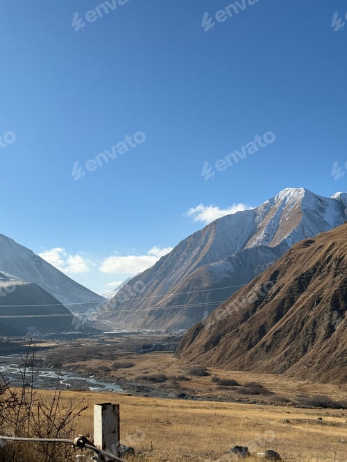 Preview: Mountain landscape with snowy peaks and clear blue sky, suitable for background and travel themes