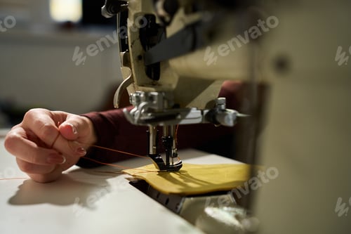 Preview: Close up of an artisan working with a heavy-duty industrial sewing machine.