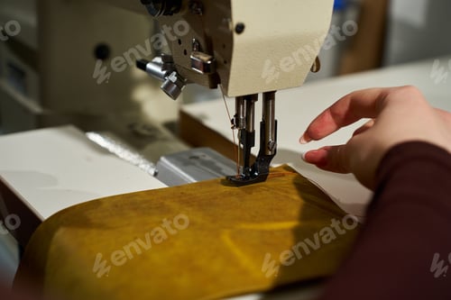 Preview: Close up of an artisan threading a heavy-duty industrial sewing machine.