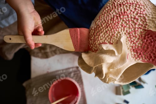 Preview: Applying decorative finish glaze to handcrafted tactile pottery with a brush.