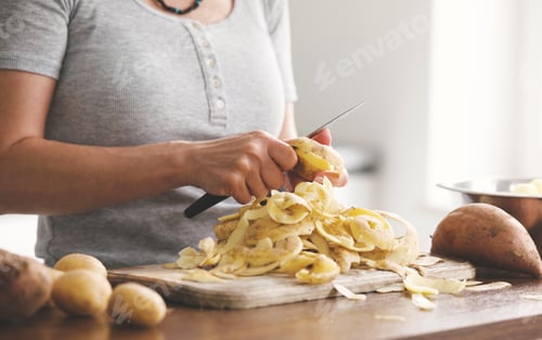 Preview: Woman Peeling Raw Potatoes For Dinner