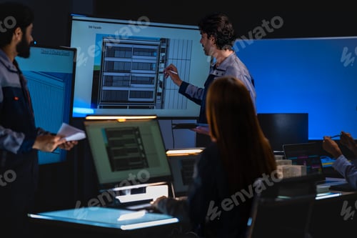 Preview: Red-haired female architect examines a building scale model in a dark architectural planning room wh