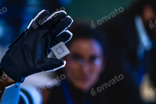 Preview: Close-up of a gloved hand presenting a CPU chip in a dark cybersecurity lab; security monitors with