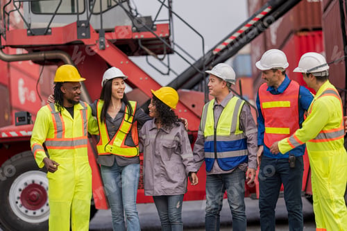Preview: Team logistics workers in high visibility safety gear and hard hats discuss operations at a busy shi