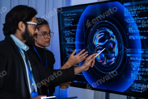 Preview: South Asian male cybersecurity analyst and Black female IT engineer with a robotic arm review digita