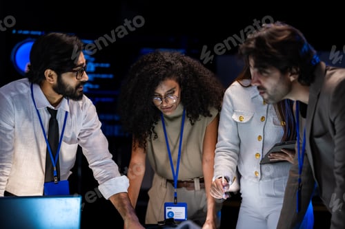Preview: Male presenter in a tan blazer gestures toward blue glowing automotive AI screens in a dark briefing