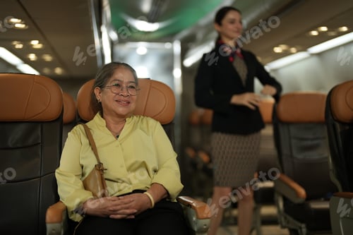 Preview: Travelers wait in an airport terminal lounge, sitting in chairs and using smartphones before their d