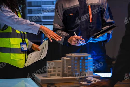 Preview: Construction team with South Asian male and red-haired female architect reviews architectural bluepr