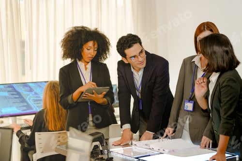 Preview: Focused cybersecurity squad reviewing predictive analytics on documents. Professional multiethnic de