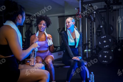 Preview: A group of diverse women sitting and having an engaging conversation while resting after their exerc