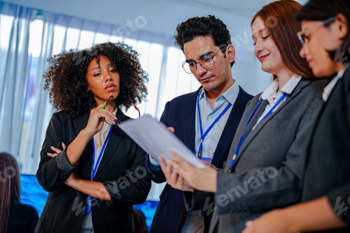 Preview: Focused African American businesswoman holding glasses and taking notes. Multiethnic group collabora