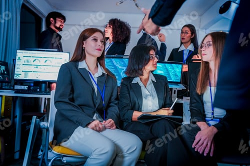 Preview: Group of attentive corporate professionals attending a nighttime training session. Diverse male and