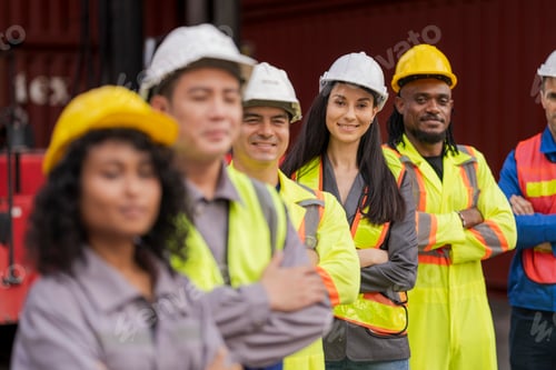 Preview: Team logistics workers in high visibility safety gear and hard hats discuss operations at a busy shi