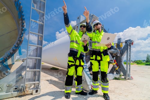 Preview: Two engineers in safety gear inspecting a wind turbine blade section on a construction site. They ex