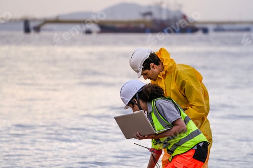Preview: Two field scientists in PPE gear analyzing seawater samples using test tubes and a laptop. Environme