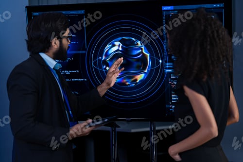 Preview: South Asian male and Black female cybersecurity professionals — she with a white robotic arm — exami