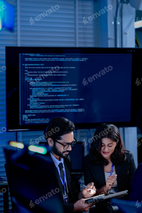Preview: Focused diverse professionals collaborate late night in a modern tech office. Colleagues discuss pro