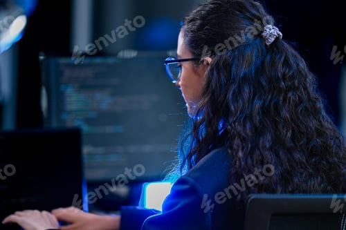 Preview: Over shoulder view of a female cybersecurity specialist analyzing firewall logs and programming syst