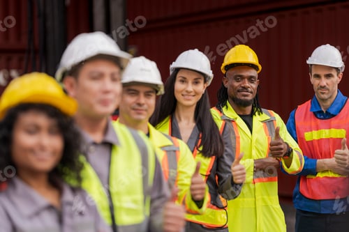 Preview: Team logistics workers in high visibility safety gear and hard hats discuss operations at a busy shi