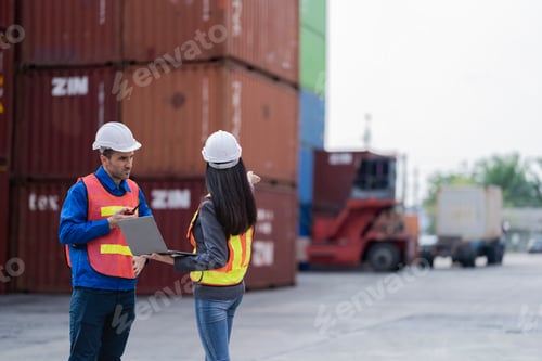 Preview: Two logistics workers man and woman discuss operations at a busy shipping container yard. successful