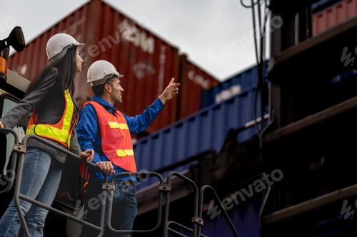 Preview: Two logistics workers man and woman discuss operations at a busy shipping container yard. successful