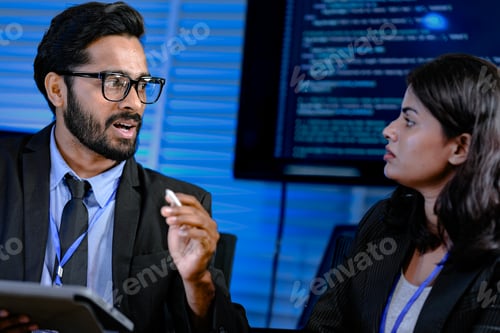 Vista previa: Sesión de estrategia enfocada a altas horas de la noche. Un gerente masculino con gafas hace gestos explicando puntos complejos a