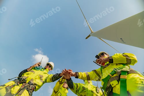 Preview: A team of engineers celebrates success after completing wind turbine maintenance at a wind farm. Ren